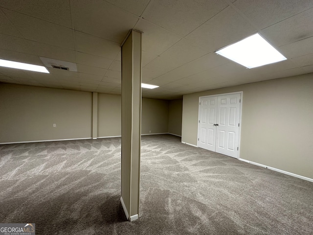 basement featuring carpet flooring and a drop ceiling