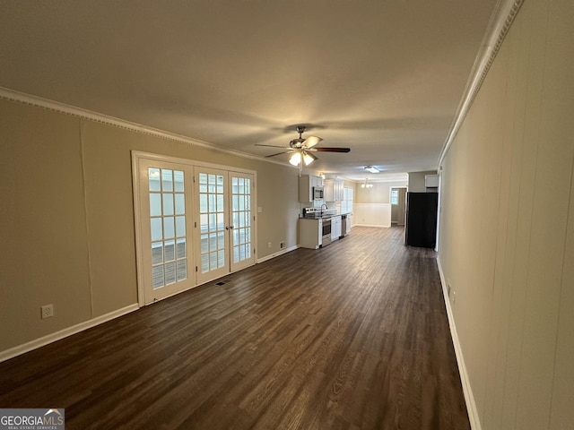 unfurnished living room featuring crown molding, ceiling fan, baseboards, dark wood-type flooring, and visible vents