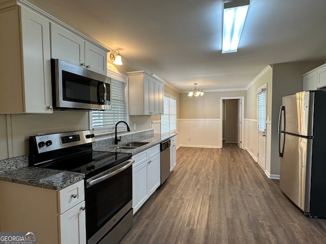 kitchen featuring ornamental molding, white cabinetry, stainless steel appliances, and sink