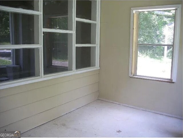 unfurnished room with unfinished concrete floors