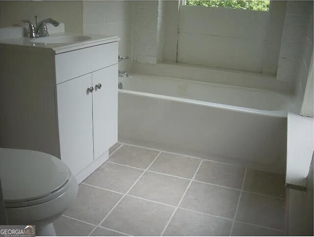 bathroom with toilet, tile patterned floors, a bath, and vanity