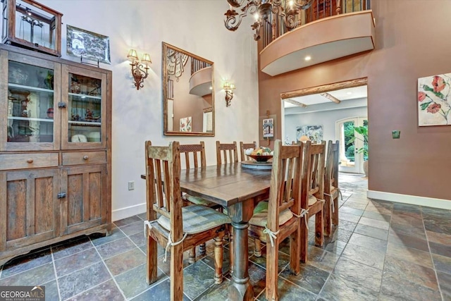 dining room featuring a towering ceiling