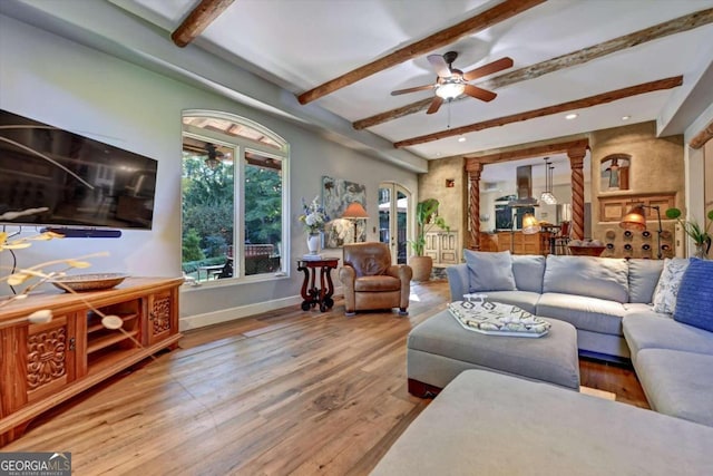 living room with beam ceiling, hardwood / wood-style flooring, and ceiling fan