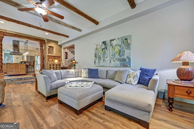 living room featuring beam ceiling, hardwood / wood-style floors, and ceiling fan