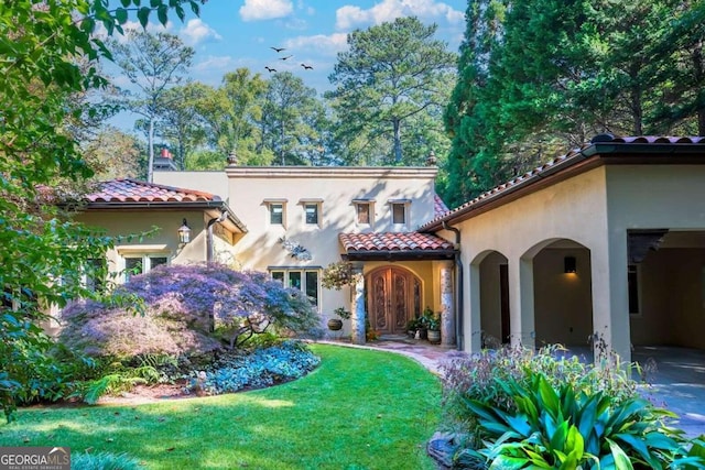 mediterranean / spanish-style home with a front lawn