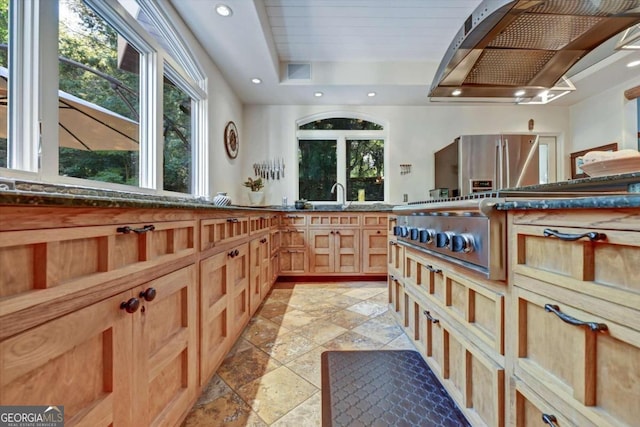 kitchen with exhaust hood, a tray ceiling, and stainless steel refrigerator