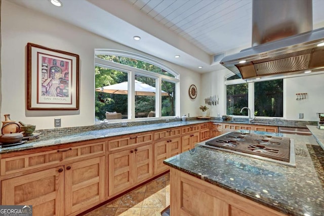 kitchen featuring island range hood, wood ceiling, dark stone countertops, sink, and stainless steel gas stovetop