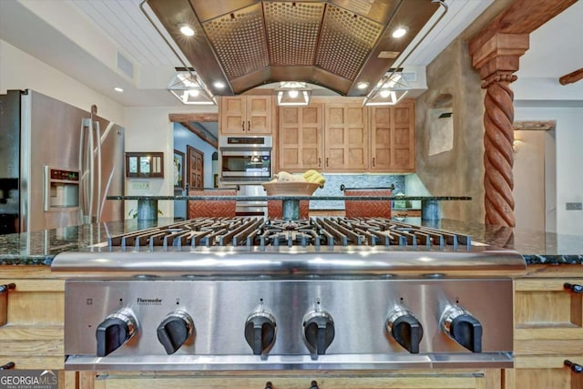 kitchen featuring island exhaust hood, appliances with stainless steel finishes, dark stone counters, and light brown cabinets