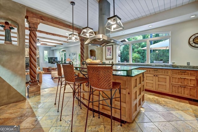 kitchen featuring beam ceiling, a breakfast bar, pendant lighting, and plenty of natural light