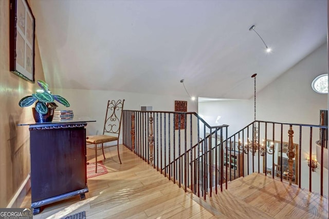 hall with light wood-type flooring and vaulted ceiling