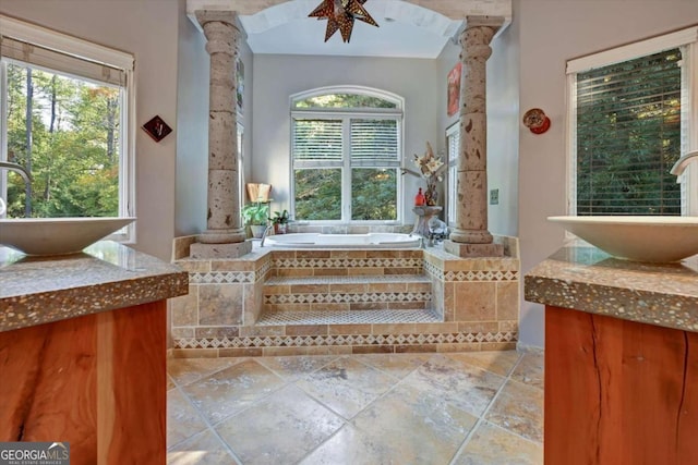 bathroom with sink, ornate columns, tiled bath, and ceiling fan