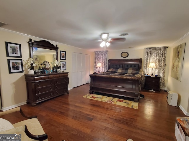 bedroom with crown molding, visible vents, a ceiling fan, wood finished floors, and baseboards