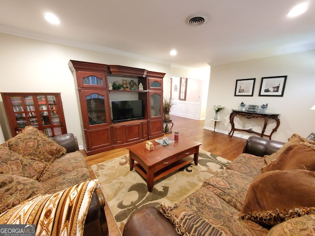 living room featuring light hardwood / wood-style flooring and crown molding