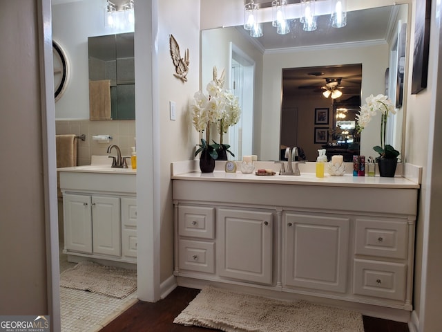 bathroom featuring ceiling fan, vanity, wood-type flooring, and ornamental molding