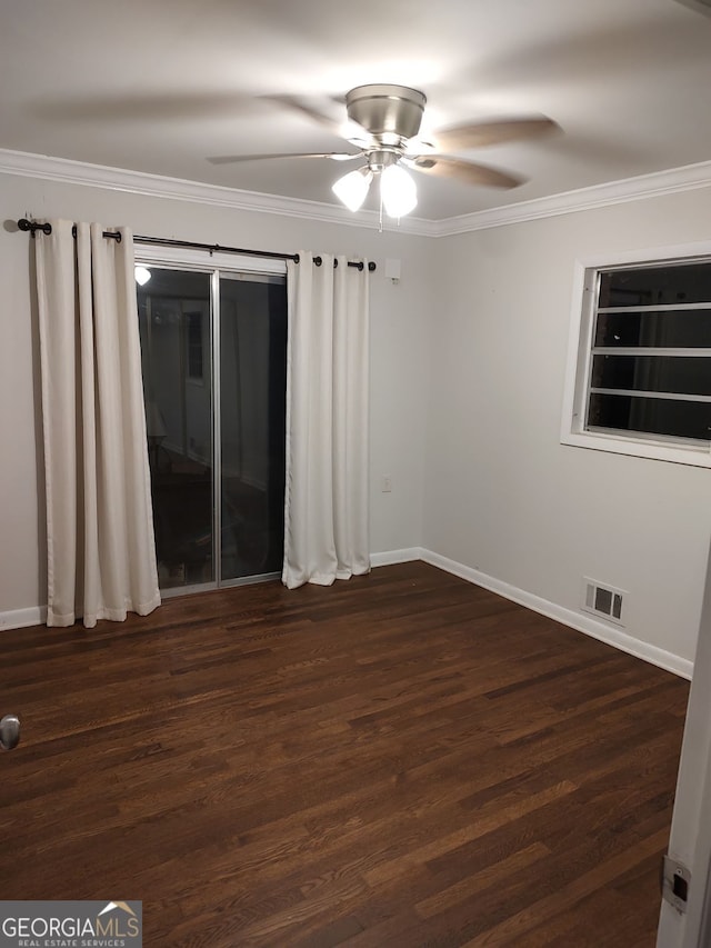 unfurnished room featuring dark wood-style flooring, crown molding, visible vents, a ceiling fan, and baseboards