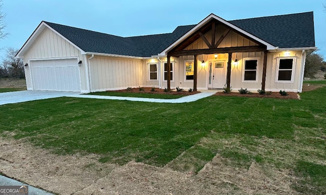 modern farmhouse style home with a garage, concrete driveway, a front lawn, and a shingled roof