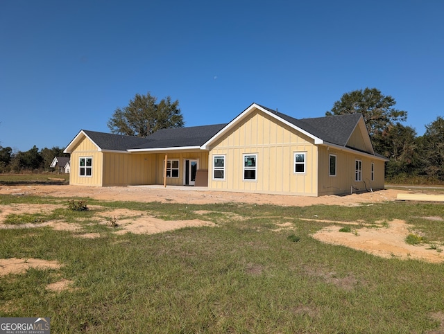 back of property featuring a yard