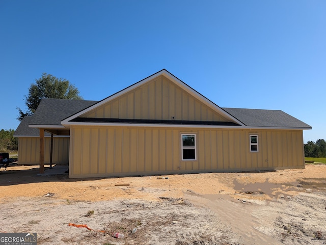 view of property exterior featuring board and batten siding and roof with shingles