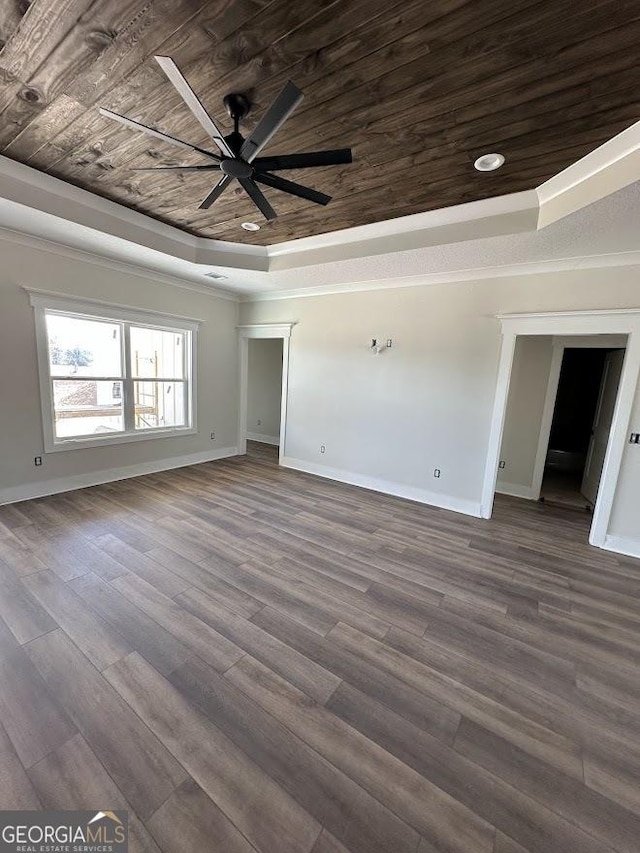 unfurnished living room featuring a tray ceiling, baseboards, wooden ceiling, and dark wood-type flooring