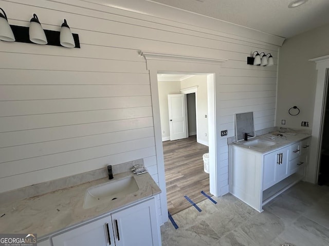 bathroom featuring wooden walls and vanity