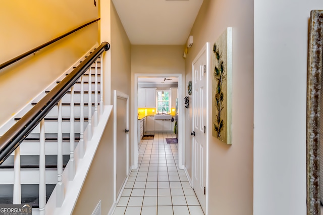 hall with sink and light tile patterned floors