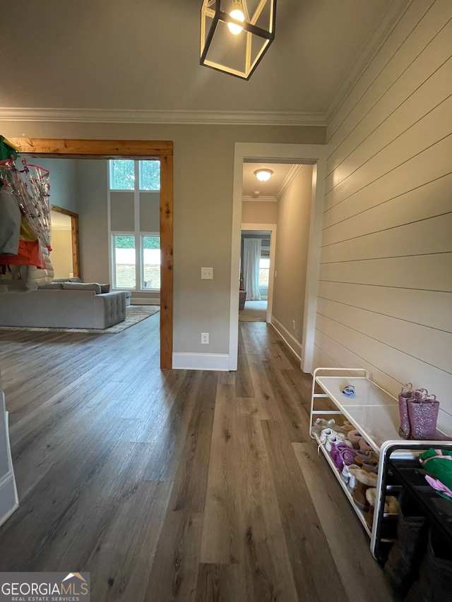 hallway with hardwood / wood-style floors, crown molding, and wood walls