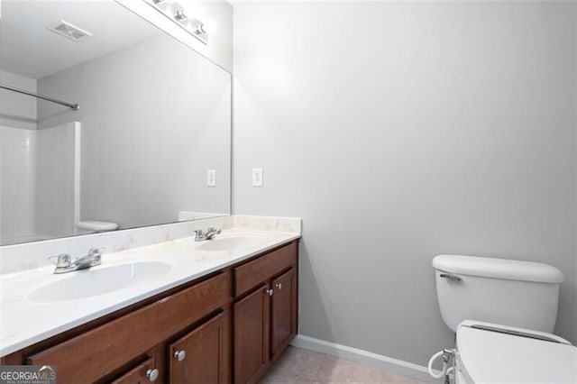 bathroom featuring walk in shower, vanity, toilet, and tile patterned flooring