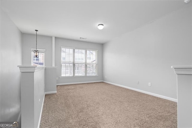 unfurnished living room with carpet floors and a chandelier