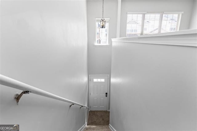 staircase featuring a notable chandelier and carpet floors