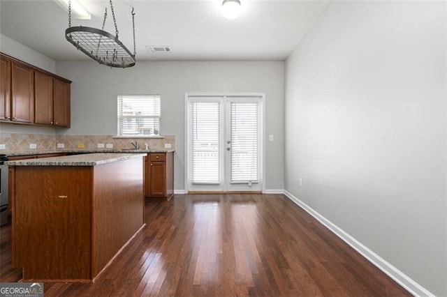 kitchen featuring dark wood-type flooring and decorative backsplash