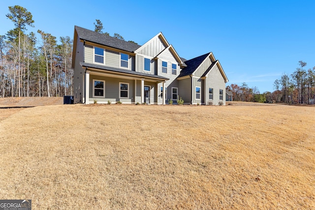 view of front of property featuring central air condition unit, a front lawn, and a porch