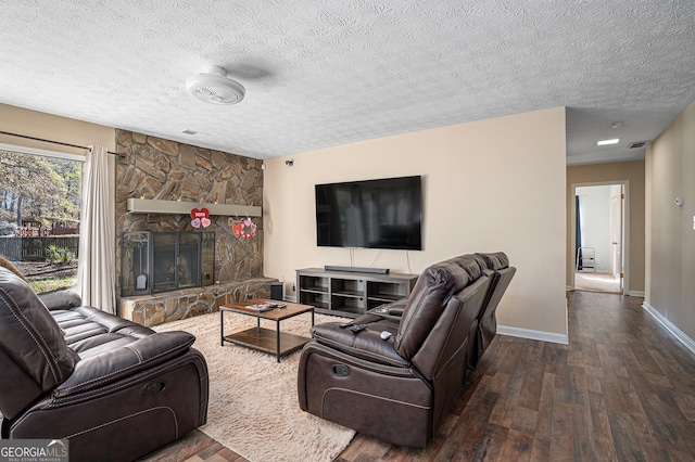 living room featuring a textured ceiling, a fireplace, and dark wood-type flooring