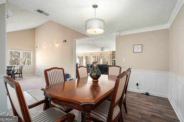 dining area featuring dark hardwood / wood-style flooring, a textured ceiling, and crown molding