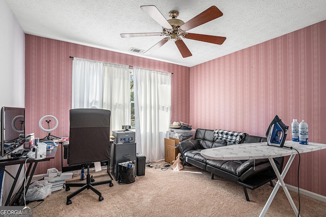 carpeted office featuring ceiling fan and a textured ceiling