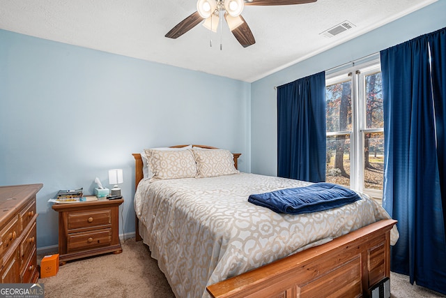 carpeted bedroom with a textured ceiling and ceiling fan