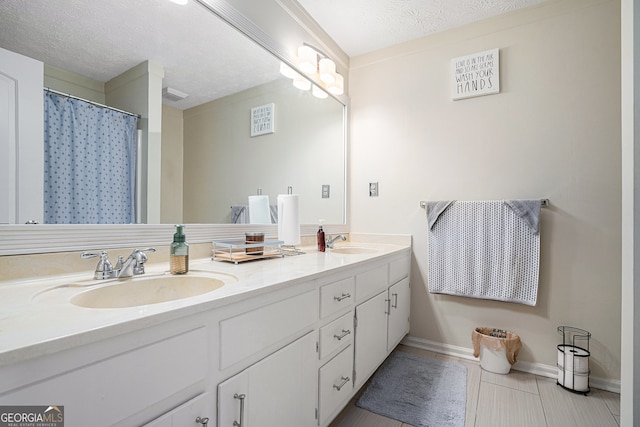 bathroom featuring a shower with curtain, tile patterned flooring, vanity, and a textured ceiling