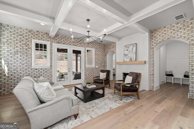 living room featuring brick wall, french doors, and wood finished floors