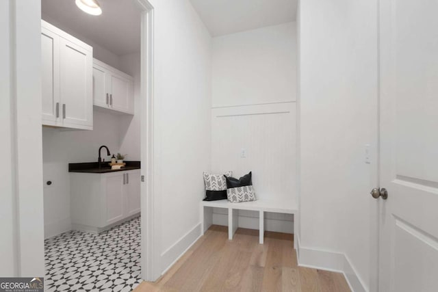 washroom featuring light wood-style floors, baseboards, and hookup for an electric dryer