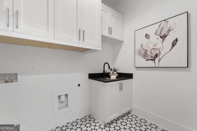 clothes washing area featuring cabinet space, baseboards, electric dryer hookup, light floors, and a sink