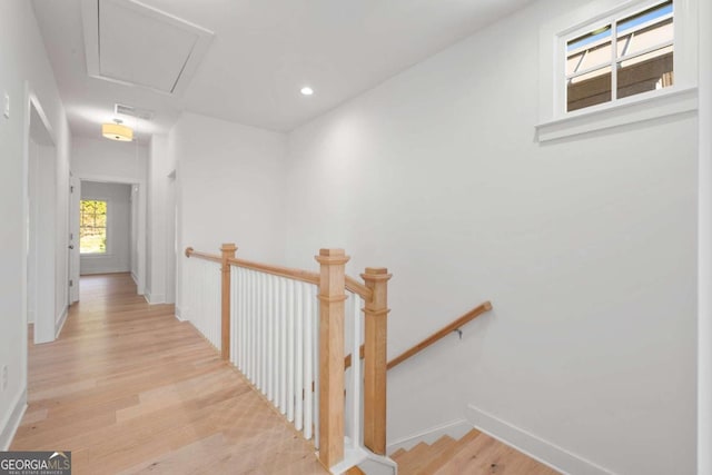 corridor featuring recessed lighting, light wood-style flooring, attic access, an upstairs landing, and baseboards