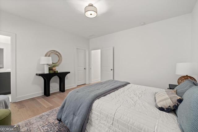 bedroom featuring wood finished floors and baseboards