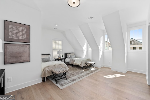 bedroom with light wood-style flooring, visible vents, and baseboards