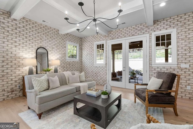 living area with french doors, visible vents, light wood-style flooring, brick wall, and beamed ceiling