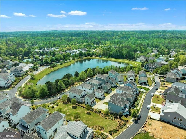 drone / aerial view featuring a water view, a residential view, and a view of trees