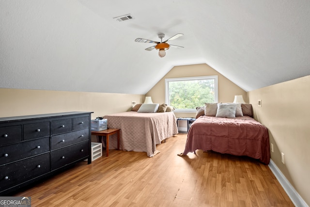 bedroom featuring light hardwood / wood-style floors, ceiling fan, and vaulted ceiling