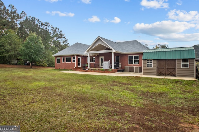 view of front of property featuring a front lawn and a storage unit