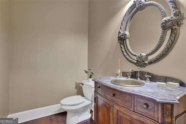 bathroom featuring vanity, toilet, and hardwood / wood-style flooring