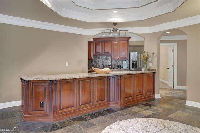 bar with crown molding, a raised ceiling, decorative backsplash, and stainless steel fridge