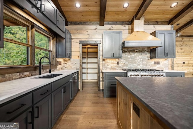 kitchen with backsplash, appliances with stainless steel finishes, hardwood / wood-style flooring, wooden ceiling, and sink