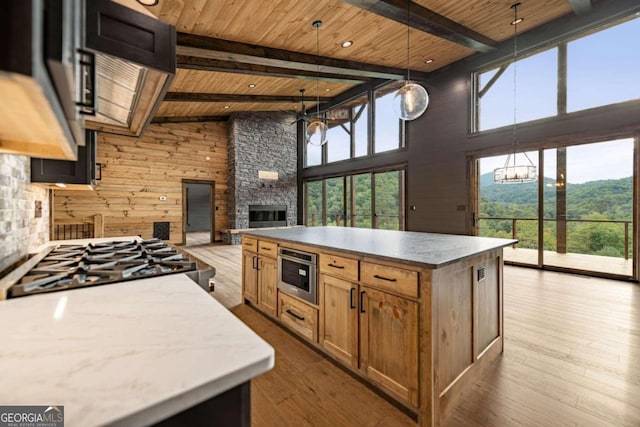 kitchen featuring light hardwood / wood-style floors, beamed ceiling, wooden ceiling, and pendant lighting